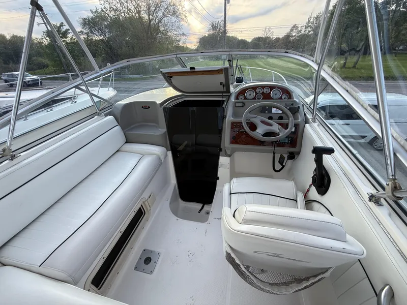 Slide: The Image of 1997 Bayliner 2655 Ciera boat interior with white seating and steering console. - 2
