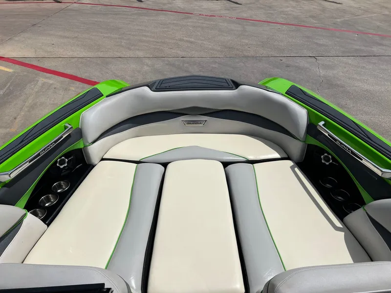 Slide: The Image of 2014 Supra SA450 boat interior with green and white seating, cup holders, and sleek design. - 13