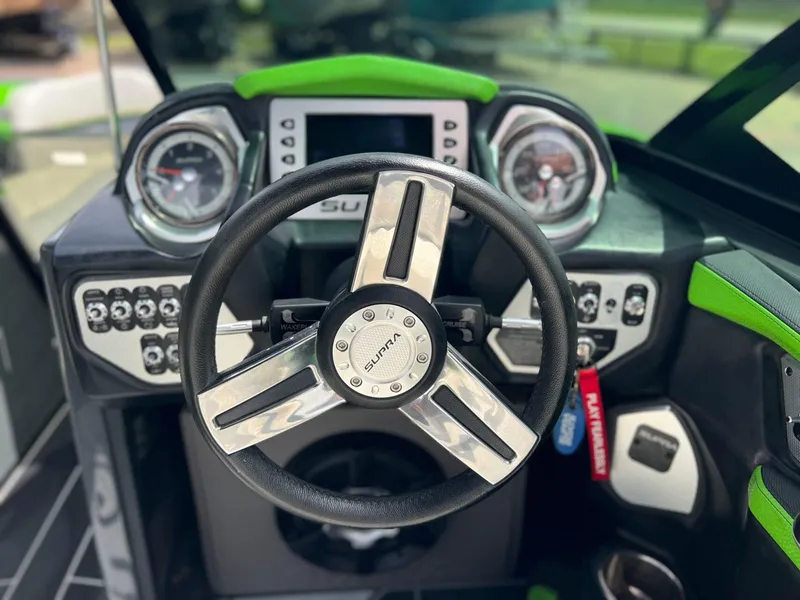 Slide: The Image of Steering wheel and dashboard of 2014 Supra SA450 boat with modern controls and gauges. - 17