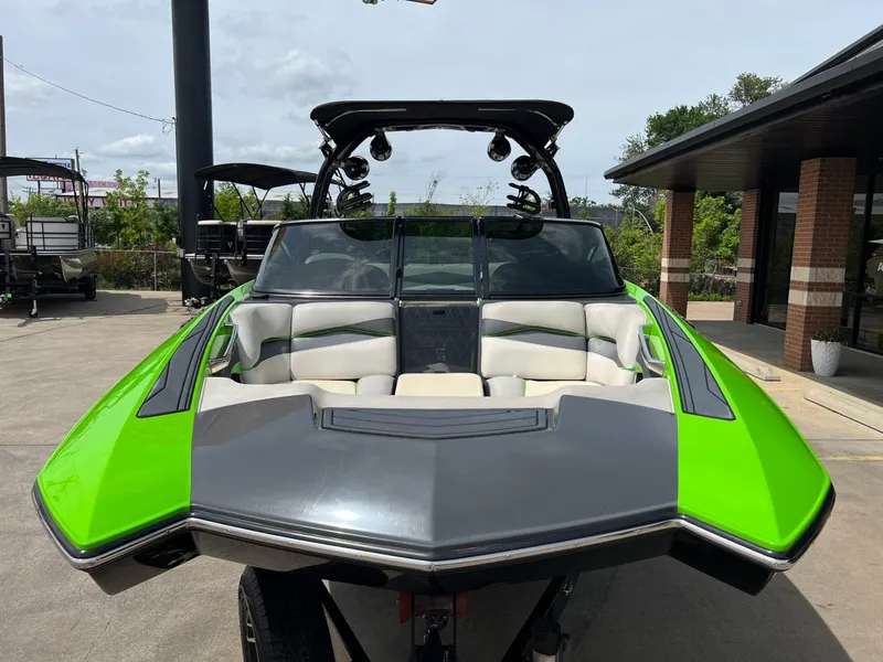Slide: The Image of 2014 Supra SA450 boat with vibrant green and gray design, parked outdoors. - 25