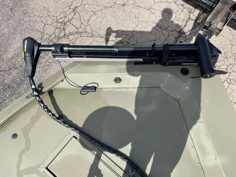 Slide: The Image of 2022 Tracker Grizzly 1648 SC boat with trolling motor on deck, shadow visible. - 12