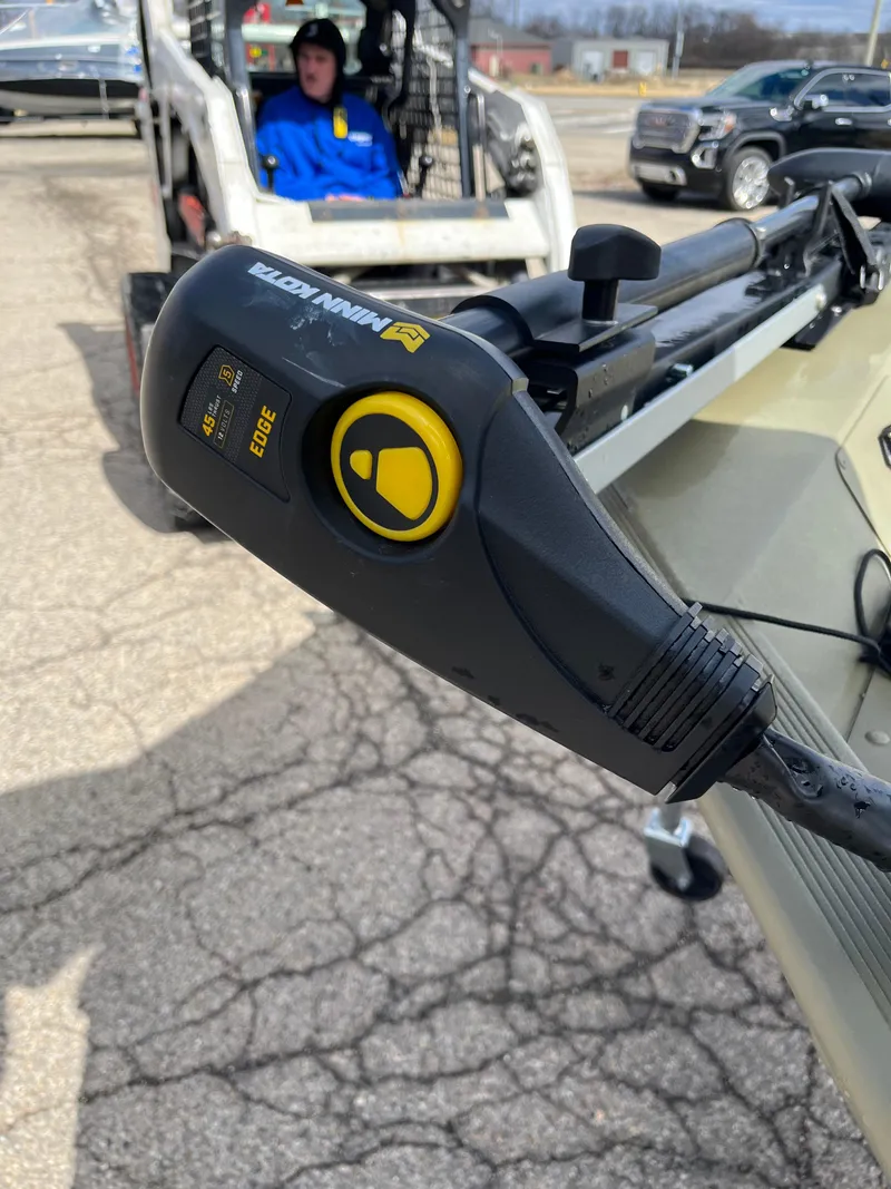 Slide: The Image of 2022 Tracker Grizzly 1648 SC boat with Minn Kota trolling motor in parking lot. - 13
