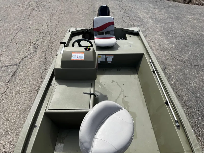 Slide: The Image of 2022 Tracker Grizzly 1648 SC boat with seating and steering console on pavement. - 3