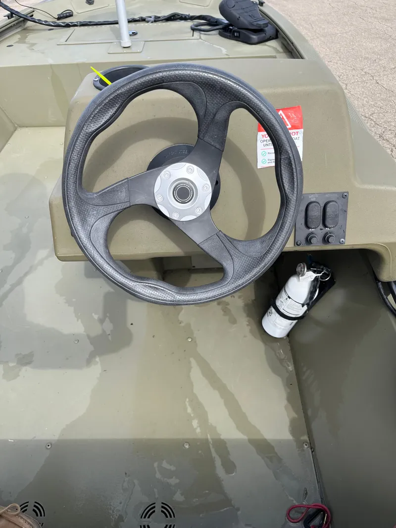 Slide: The Image of Steering wheel of 2022 Tracker Grizzly 1648 SC boat with control panel and fire extinguisher. - 7