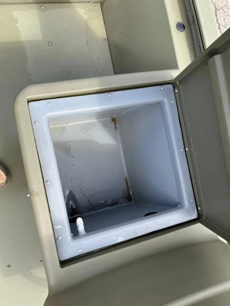 Slide: The Image of 2022 Tracker Grizzly 1648 SC boat storage compartment, open lid, empty interior. - 8
