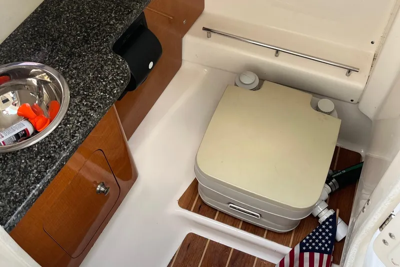 Slide: The Image of 2009 Chaparral Sunesta 284 boat interior with portable toilet and sink. - 10