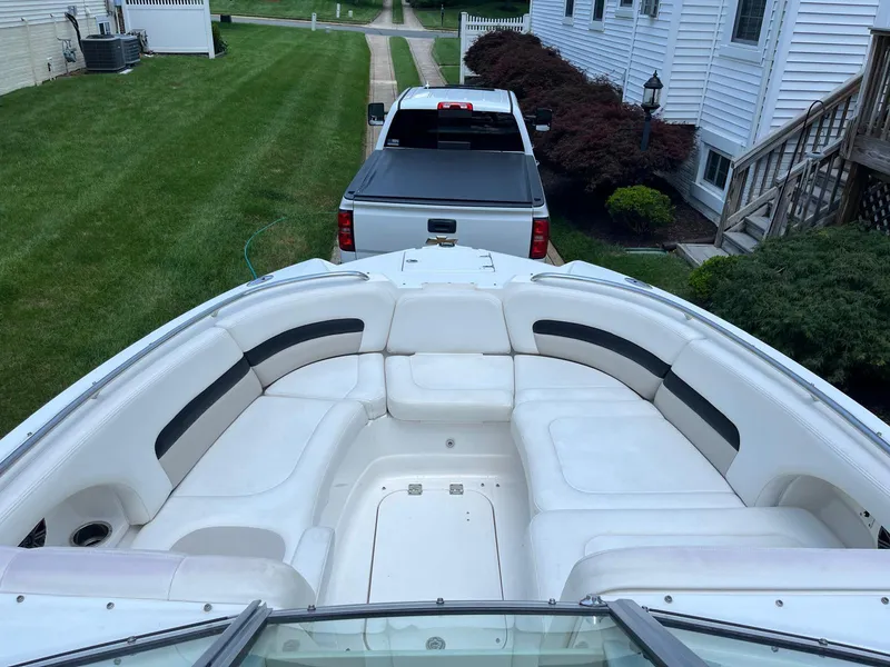 Slide: The Image of 2008 Chaparral Sunesta 284 boat with spacious seating, parked near a white truck. - 16