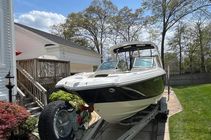 Slide: The Image of 2009 Chaparral Sunesta 284 boat on trailer, parked beside a house on a sunny day. - 6
