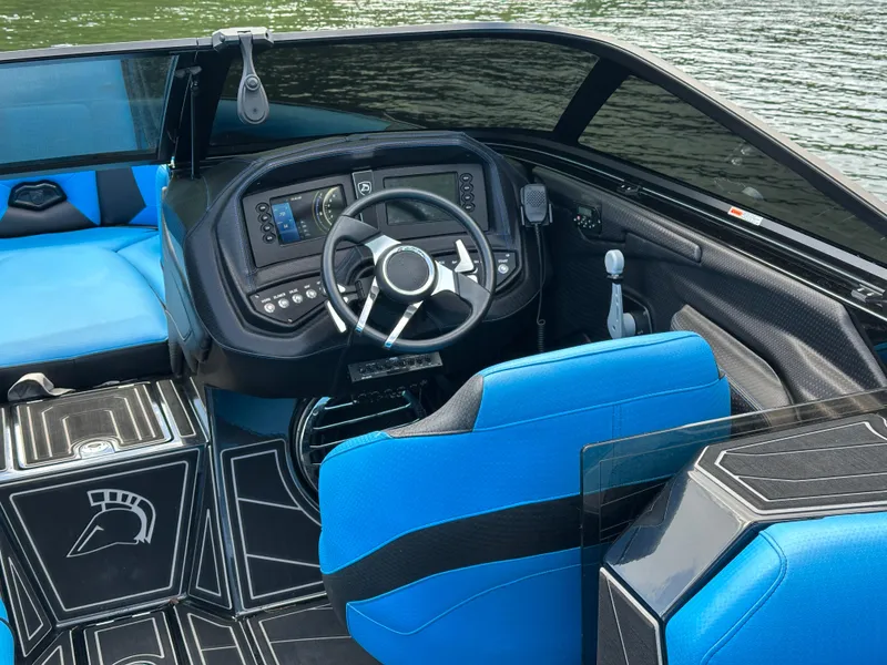 Slide: The Image of 2019 Centurion Ri257 boat interior with blue seating and modern dashboard controls. - 10
