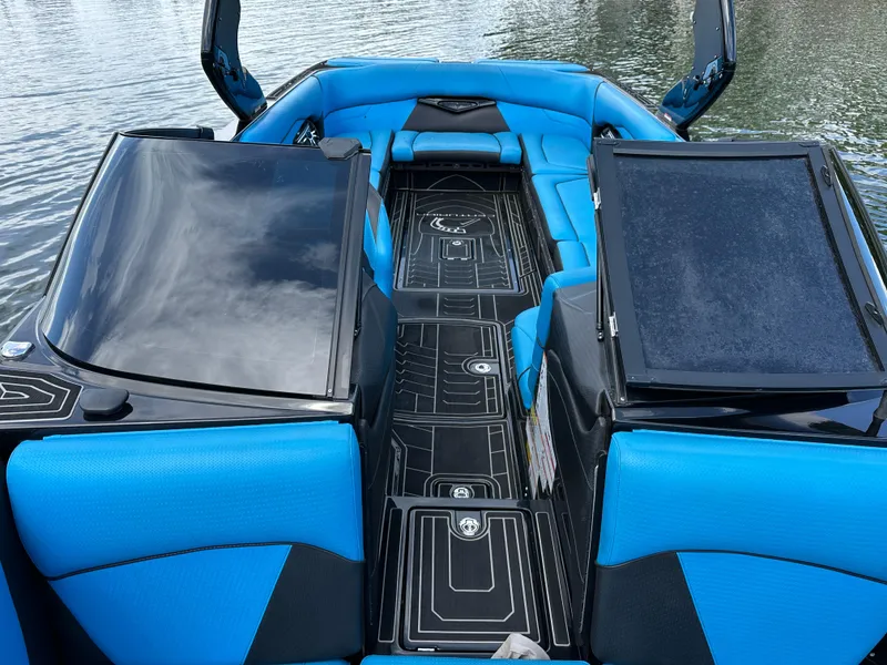 Slide: The Image of 2019 Centurion Ri257 boat interior with blue and black seating on water. - 12