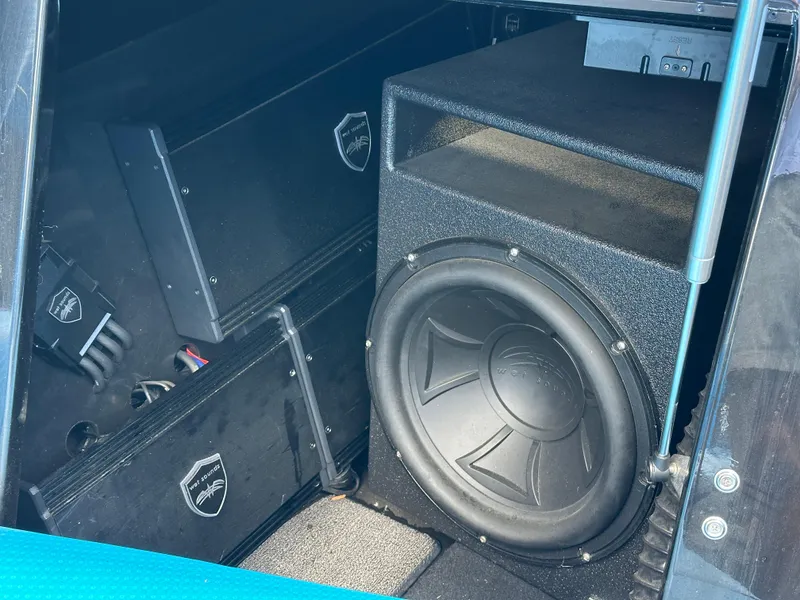Slide: The Image of 2019 Centurion Ri257 audio system with subwoofer and amplifiers in storage compartment. - 16