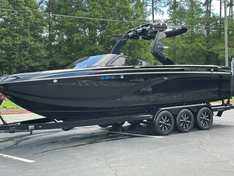 Slide: The Image of 2019 Centurion Ri257 boat on trailer, sleek black design, parked outdoors. - 17