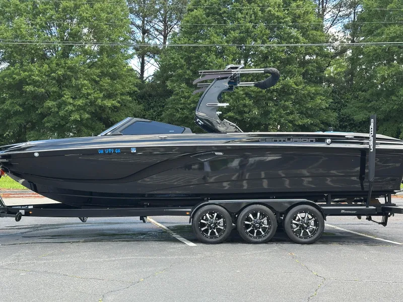 Slide: The Image of 2019 Centurion Ri257 boat on trailer, sleek black design, parked outdoors. - 18