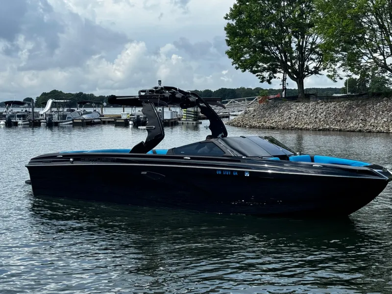 Slide: The Image of 2019 Centurion Ri257 boat on a lake with cloudy sky and trees. - 2