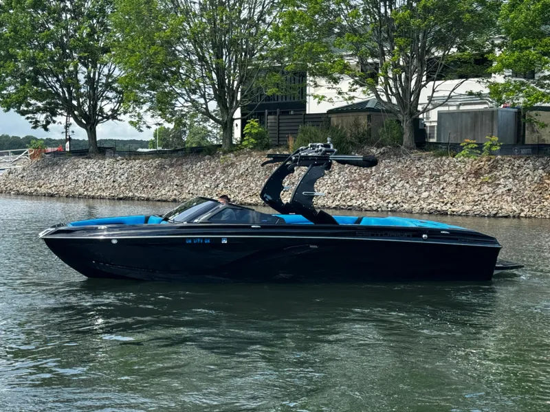 Slide: The Image of 2019 Centurion Ri257 boat on a calm lake with trees in the background. - 4