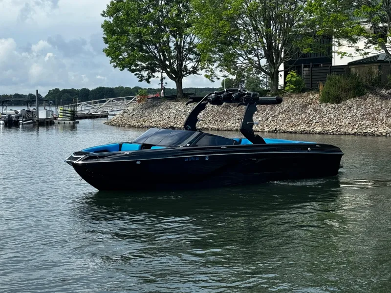 Slide: The Image of 2019 Centurion Ri257 boat on a calm lake near a rocky shoreline and trees. - 5