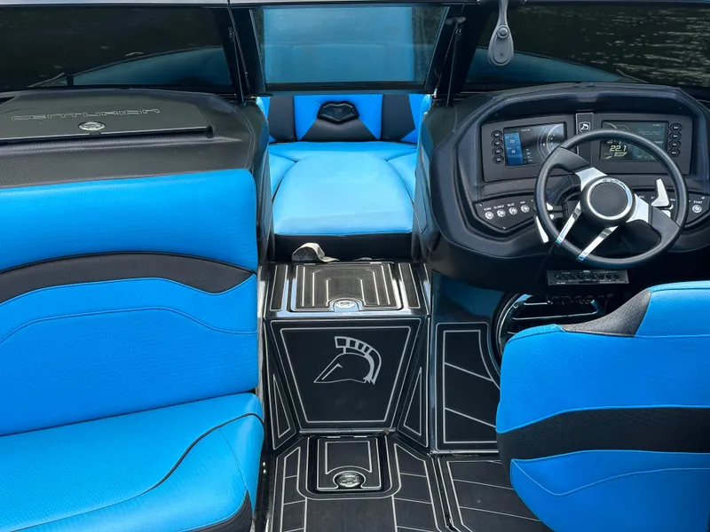 Slide: The Image of 2019 Centurion Ri257 boat interior with blue and black seating, modern dashboard, and sleek design. - 9
