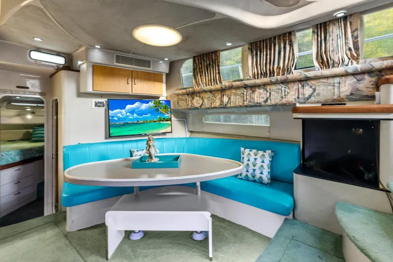 Slide: The Image of Interior of 1996 Mainship 37 Aft Cabin with turquoise seating and a mounted TV. - 18