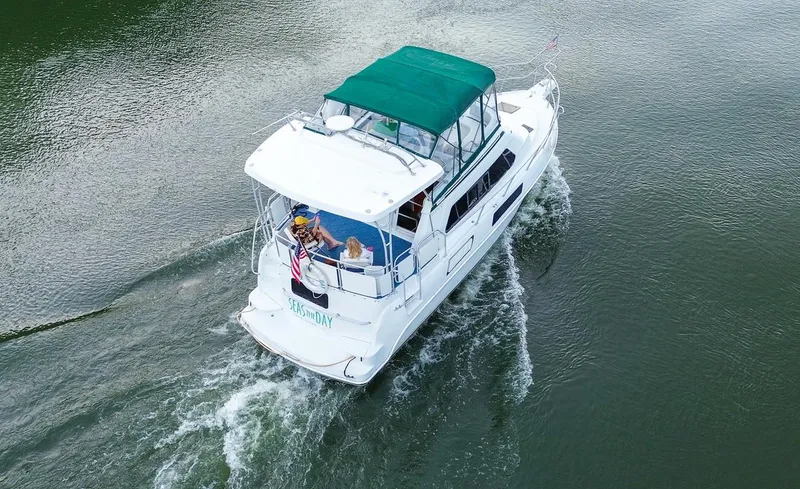 Slide: The Image of 1996 Mainship 37 Aft Cabin cruising on calm water with green canopy. - 2