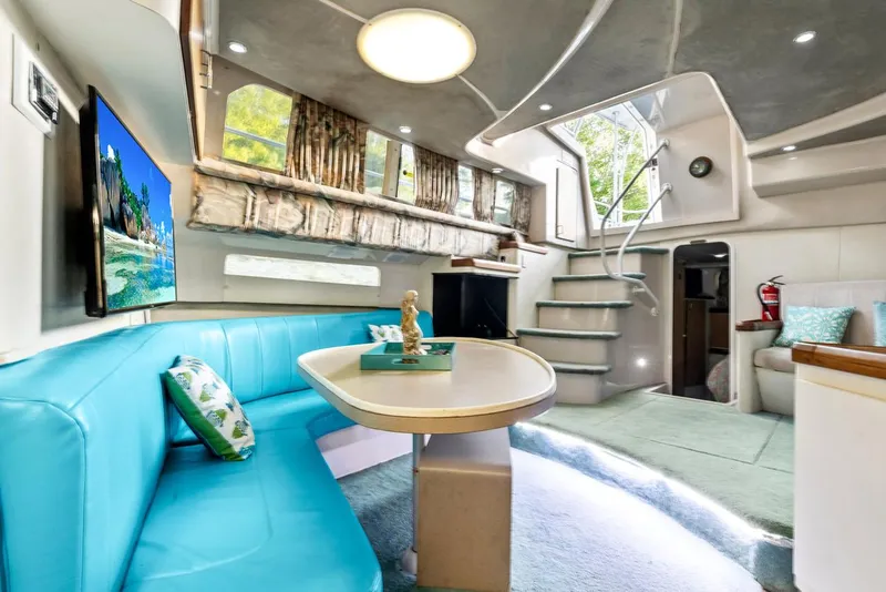 Slide: The Image of 1996 Mainship 37 Aft Cabin interior with turquoise seating, dining table, and modern decor. - 20