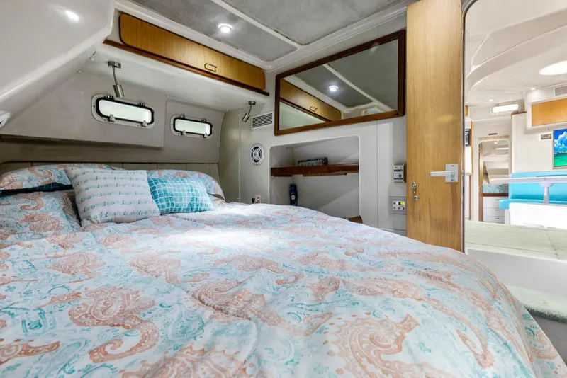 Slide: The Image of Cozy bedroom in 1996 Mainship 37 Aft Cabin yacht with patterned bedding and wood accents. - 30