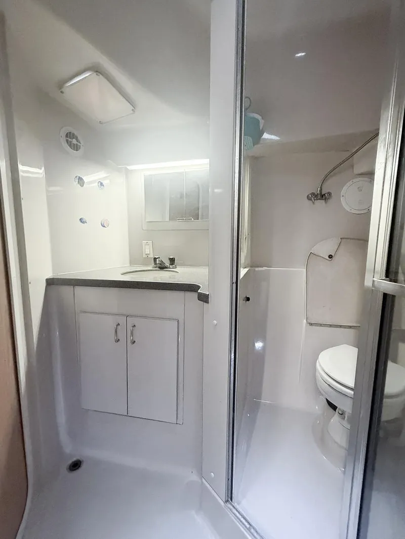 Slide: The Image of Bathroom interior of 1996 Mainship 37 Aft Cabin yacht, featuring shower and toilet. - 32
