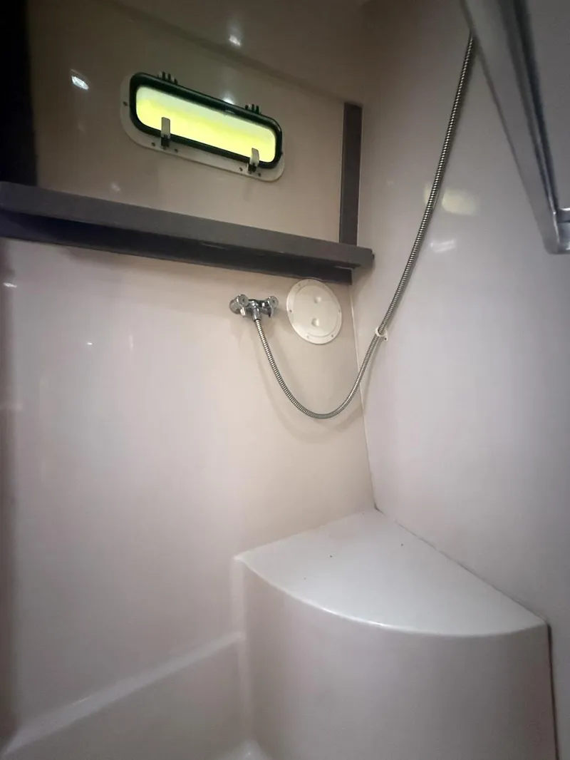 Slide: The Image of 1996 Mainship 37 Aft Cabin shower area with window and showerhead. - 33