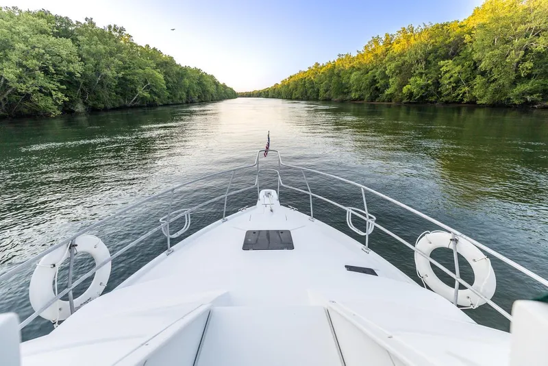Slide: The Image of Bow view of 1996 Mainship 37 Aft Cabin cruising on a serene river. - 9