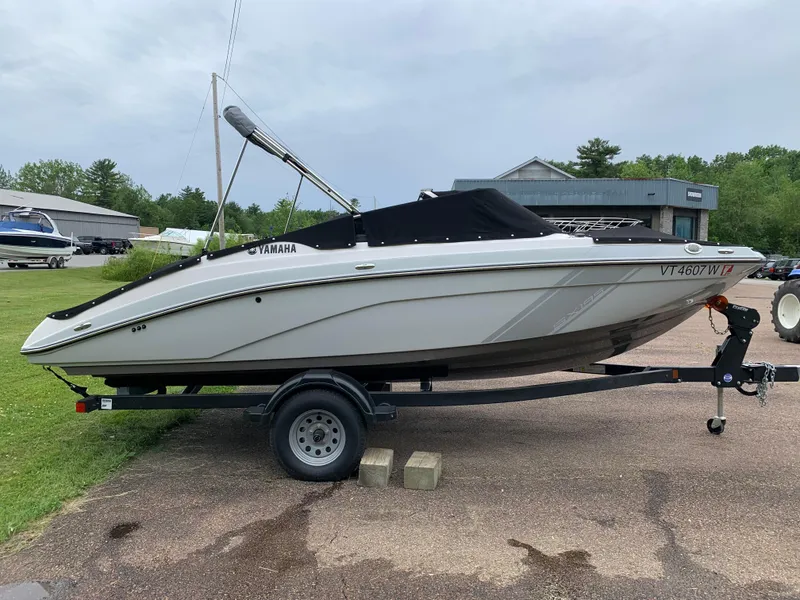 Slide: The Image of 2023 Yamaha SX195 boat on trailer, parked outdoors, side view. - 10
