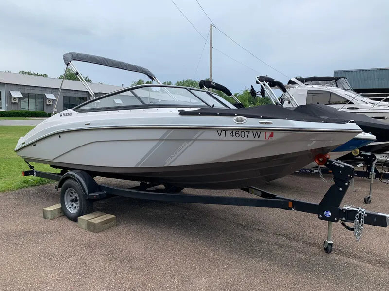Slide: The Image of 2023 Yamaha SX195 boat on trailer, parked outdoors, side view. - 14