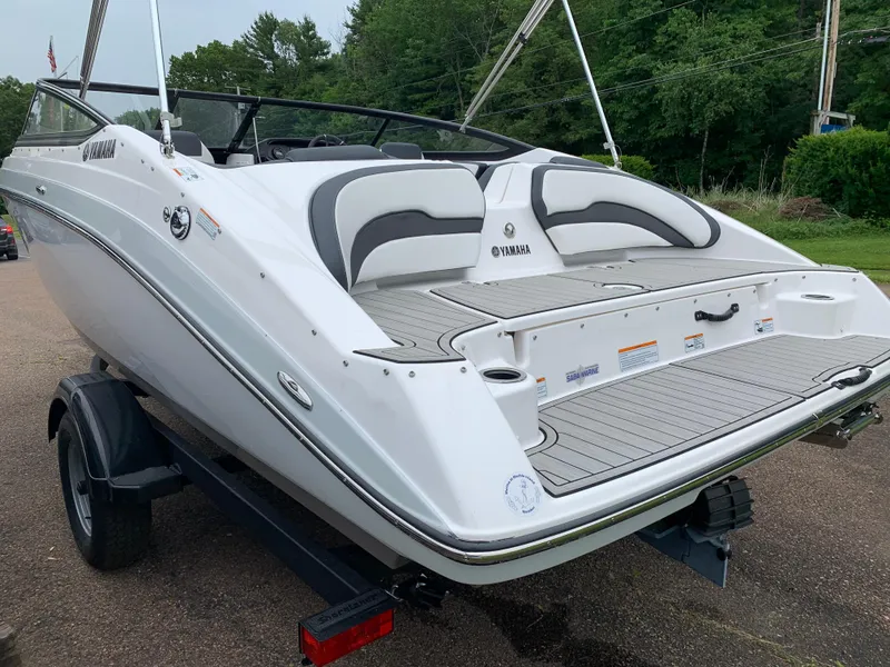 Slide: The Image of 2023 Yamaha SX195 boat on trailer, rear view, white exterior, sleek design, outdoor setting. - 16