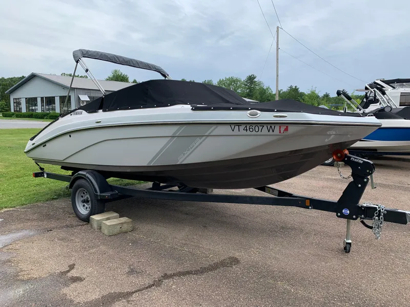 Slide: The Image of 2023 Yamaha Boats SX195 on trailer, covered, parked outdoors. - 9
