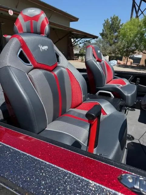 Slide: The Image of 2025 Ranger Z521R boat seats with red and gray design, outdoors. - 7