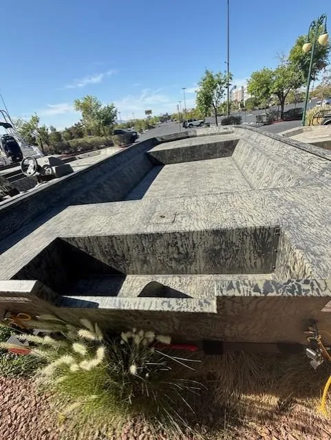 Slide: The Image of 2025 Tracker GRIZZLY 2072 Utility boat with camouflage design, parked outdoors. - 3