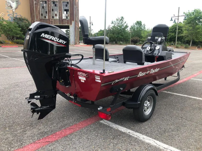 Slide: The Image of 2025 Tracker Bass Tracker Classic XL boat with Mercury engine in a parking lot. - 4