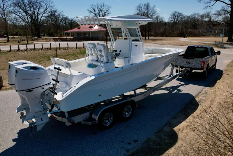 Slide: The Image of 2025 Cape Horn 24 XS boat on trailer, hitched to a truck, parked outdoors. - 0