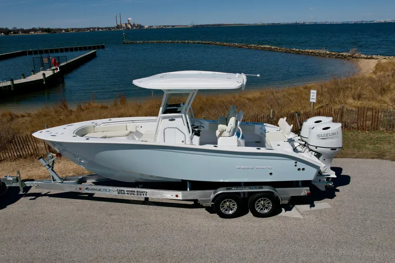 Slide: The Image of 2025 Cape Horn 24 XS boat on trailer by waterfront, clear sky, and scenic view. - 1