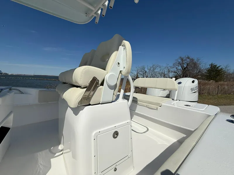 Slide: The Image of 2025 Cape Horn 24 XS boat interior with cushioned seating and Suzuki outboard motor. - 21