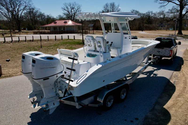 Slide: The Image of 2025 Cape Horn 24 XS boat on trailer, parked outdoors, with dual engines. - 7