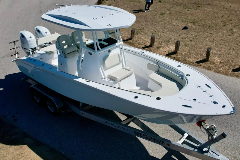 Slide: The Image of 2025 Cape Horn 24 XS boat on trailer, parked on a road near grassy area. - 8