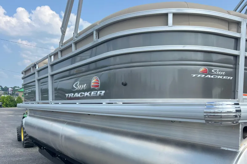 Slide: The Image of 2025 Sun Tracker Party Barge 20 DLX pontoon boat, silver exterior, parked outdoors. - 4