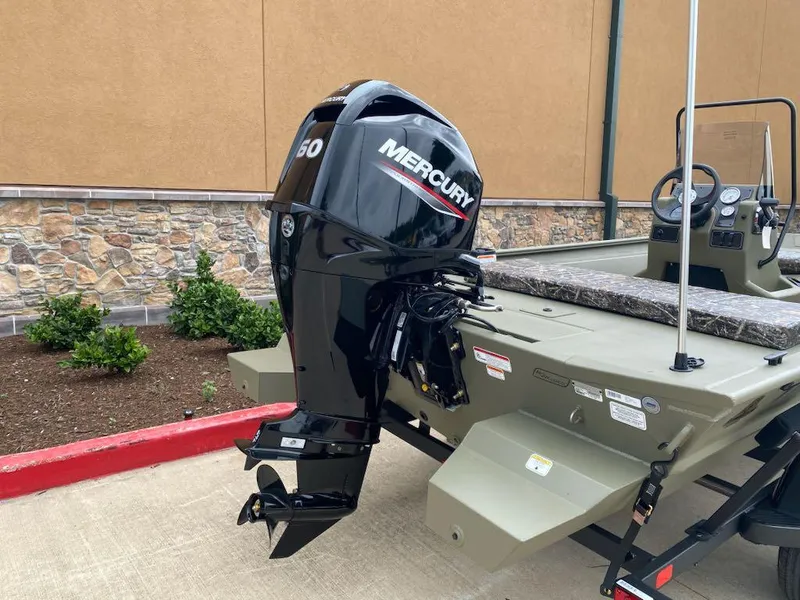 Slide: The Image of 2025 Tracker Grizzly 1860 CC boat with Mercury outboard motor, parked outdoors. - 5