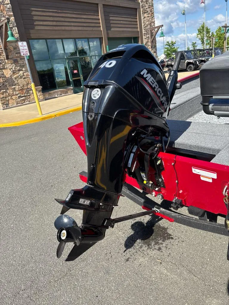 Slide: The Image of 2025 Tracker Super Guide V-16 T with Mercury outboard motor, parked outdoors. - 3
