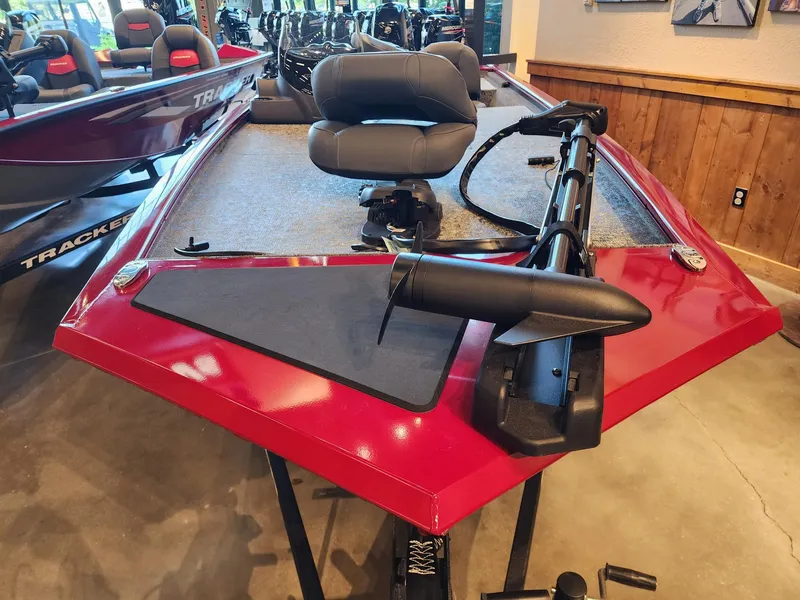 Slide: The Image of 2025 Tracker Pro 170 boat with red exterior and seating, displayed indoors. - 2
