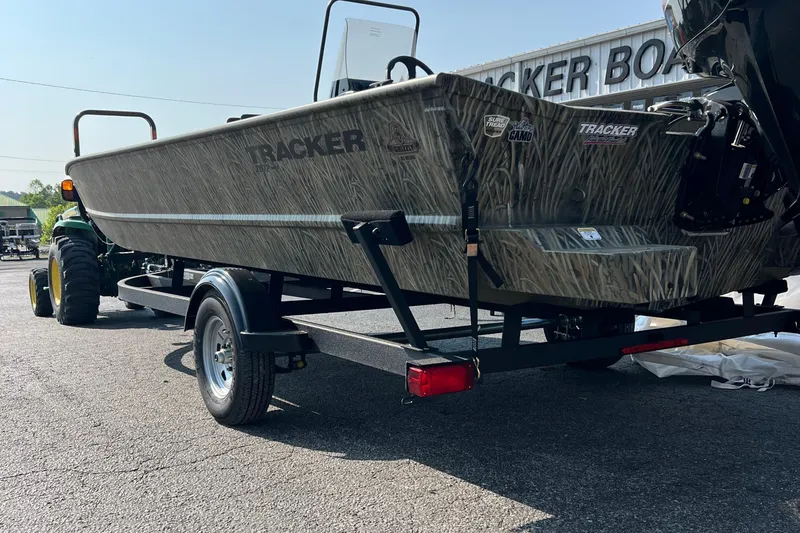 Slide: The Image of 2025 Tracker Grizzly 2072 CC boat on trailer, parked outdoors, side view. - 10