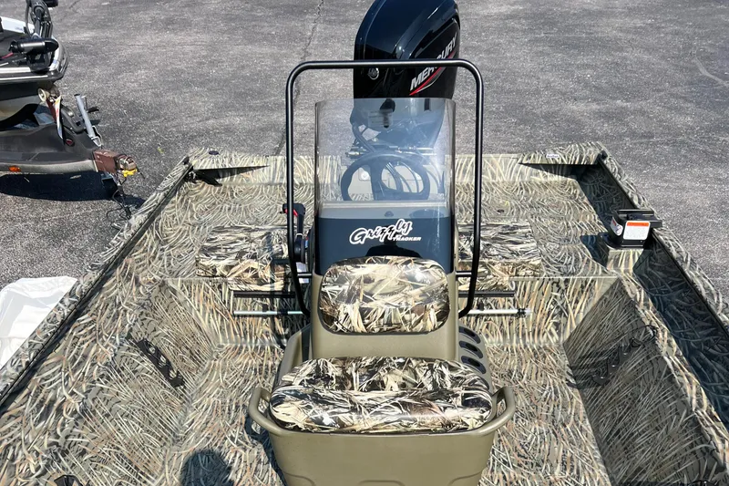 Slide: The Image of 2025 Tracker Grizzly 2072 CC boat with camouflage seating and Mercury outboard motor. - 11
