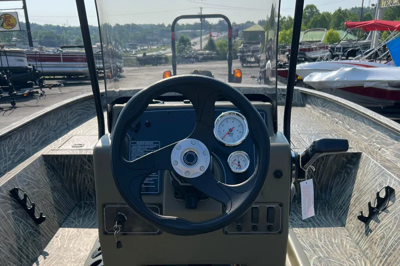Slide: The Image of 2025 Tracker Grizzly 2072 CC boat dashboard with steering wheel and gauges. - 3