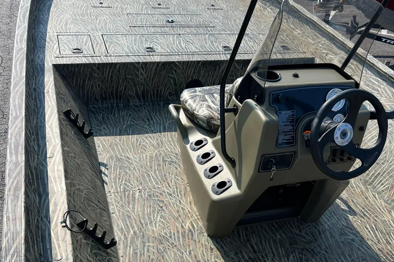 Slide: The Image of 2025 Tracker Grizzly 2072 CC boat interior with camo design and steering console. - 4