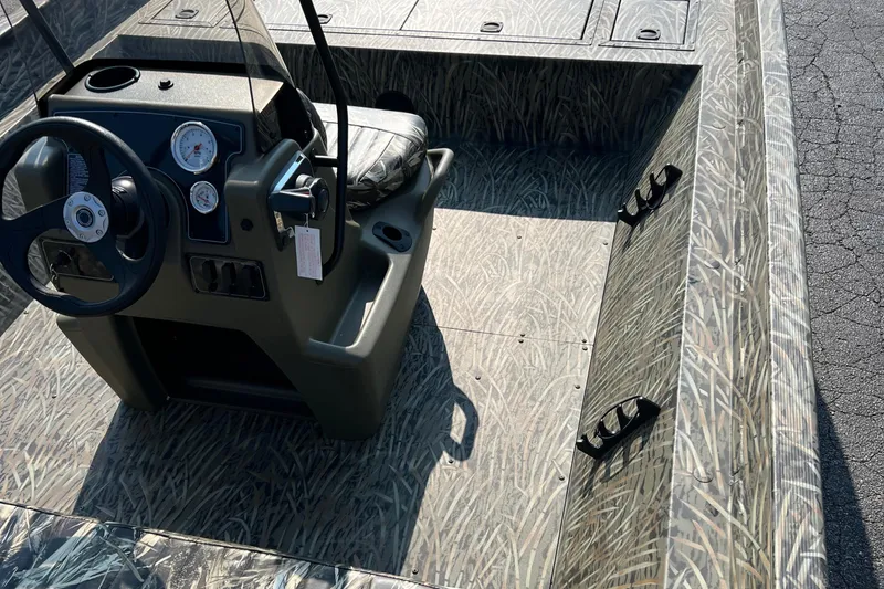 Slide: The Image of 2025 Tracker Grizzly 2072 CC boat interior with steering console and camouflage design. - 5