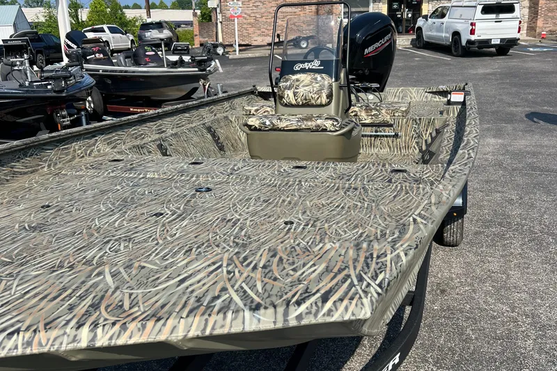 Slide: The Image of 2025 Tracker Grizzly 2072 CC boat with camouflage design in a parking lot. - 6